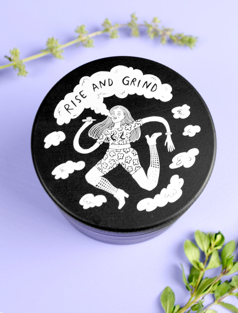 ceramic cannabis grinder that says Rise and Grind with an illustration of a woman smoking a joint